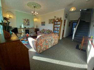 a living room with a couch and a staircase at Hele Beach in Ilfracombe