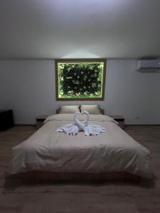 una camera da letto con un letto con due asciugamani bianchi di Casa Ratiu Airport Bucharest Therme Bucharest a Baloteşti