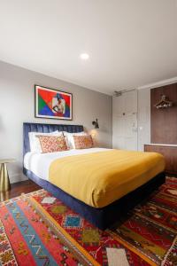 a bedroom with a large bed with a yellow blanket at Utopian Hotel, a charming guesthouse in Porto