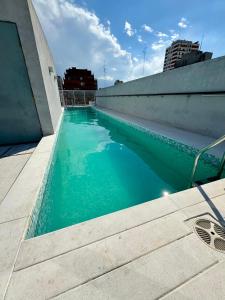 una piscina de agua azul junto a un edificio en Foster Recoleta en Buenos Aires