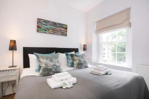 a bedroom with a large bed with towels on it at Historic House On The Bridge in Bath