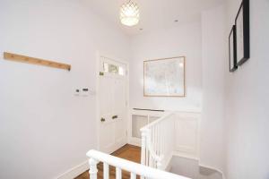 a white staircase in a white room with a window at Historic House On The Bridge in Bath