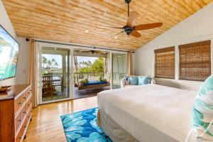 - une chambre avec un lit et un ventilateur de plafond dans l'établissement Cute 4br home steps to the Ocean - Alekona Kauai, à Koloa