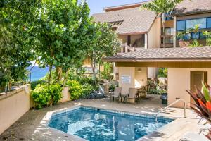 a swimming pool in front of a house at Unique Oceanfront Condo with AC- Alekona Kauai in Koloa