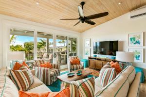 a living room with couches and a flat screen tv at 4BR Poipu Home with Private Pool- Alekona Kauai in Koloa
