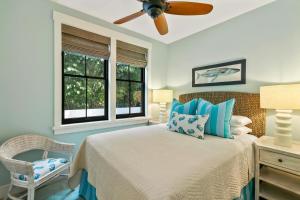 a bedroom with a bed with a ceiling fan and a chair at 4BR Poipu Home with Private Pool- Alekona Kauai in Koloa +34 photos
