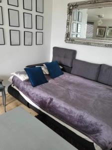 ein großes lila Bett in einem Zimmer mit Spiegel in der Unterkunft Beautiful apartment in SW London in Sutton