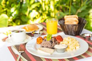 una mesa con un plato de comida y una taza de café en Hotel Lavas Tacotal en Fortuna