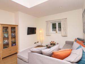 a living room with a couch and a tv at Little Silver Nugget in High Bickington