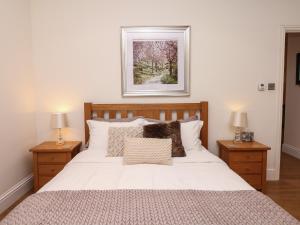 1 dormitorio con 1 cama blanca grande y 2 mesitas de noche en Little Silver Nugget, en High Bickington