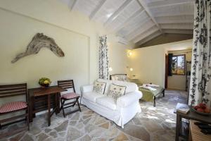 a living room with a white couch and a bedroom at Agathi Cottage in Longos