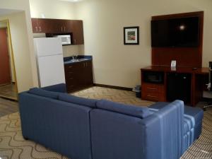 sala de estar con sofá azul y TV en Wingate by Wyndham Buckhannon, en Buckhannon