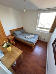 Habitación pequeña con cama y ventana en Elkington Point, en Londres