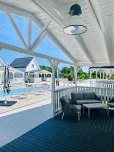eine Veranda mit einem Sofa, einem Tisch und einem Pool in der Unterkunft Resort Golf Kołczewo in Kołczewo