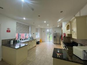 a large kitchen with white cabinets and a counter top at Canford house on Westbury on Trym in Bristol