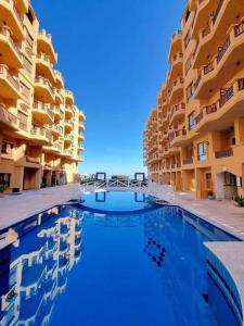 una gran piscina en medio de un edificio en Lovely bedroom apartment TBR, en Hurghada