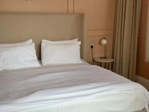 een bed met witte lakens en kussens in een kamer bij شاليهـات موركوت in El Mutainiyat