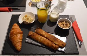 a table with a plate of food with bread and orange juice at Au fil du temps in Amboise