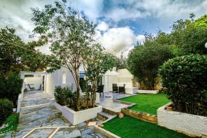 einen Garten mit einem Baum inmitten eines Gartens in der Unterkunft Athens Voula garden bungalow in Athen