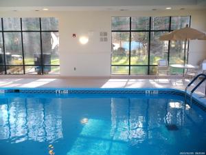 einen Pool mit blauem Wasser in einem Zimmer mit Fenstern in der Unterkunft Wingate by Wyndham Buckhannon in Buckhannon