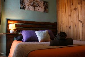 um quarto com uma cama com almofadas roxas e brancas em Casa rural Hitohouse Bed&Climb em Albarracín