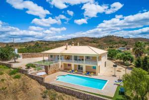 een luchtzicht op een huis met een zwembad bij Villa Entrecolinas in São Bartolomeu de Messines