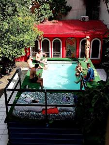 een groep mensen die rond een zwembad zitten bij Zebulo Hostel in Panama-Stad
