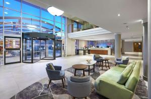 een lobby met een bank, stoelen en een tafel bij Hilton London Croydon in Croydon