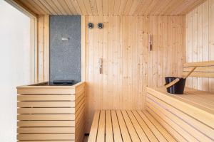 a sauna with a wooden floor and a tub at Hilton London Croydon in Croydon