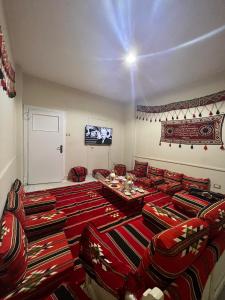 a living room with couches and tables and a television at Le Caire Guest Hous cairo in Cairo