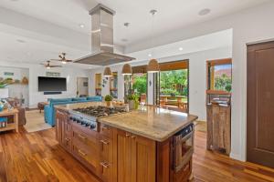 a kitchen with a stove and a living room at Custom 4br Home Walking Distance to Beach - Alekona Kauai in Koloa