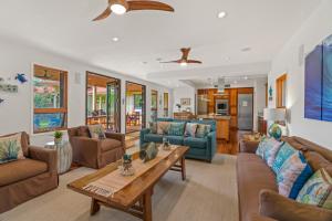 a living room with couches and a table at Custom 4br Home Walking Distance to Beach - Alekona Kauai in Koloa