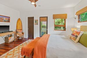 a bedroom with a bed and a surfboard in it at Custom 4br Home Walking Distance to Beach - Alekona Kauai in Koloa