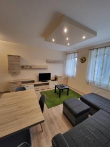 a living room with a couch and a table at TriAngol Apartman: fürdő, belváros, egyetem in Győr