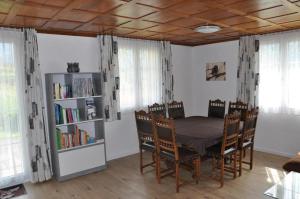 una sala da pranzo con tavolo, sedie e libreria di Ferienwohnung Sagenmattli ad Arth