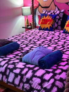 einem lila Bett mit Kissen darüber in der Unterkunft *ARCADE.ROOM* 