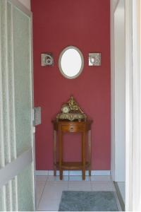 a room with a red wall and a table with a mirror at Ferien Wohnung Weinheim - Die FeWo i.d. Nordstadt in Weinheim