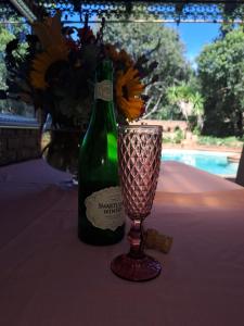 a green bottle of wine and a vase on a table at La Cheteau B&B in Springs