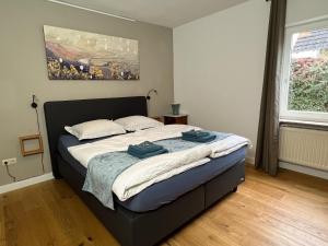 1 dormitorio con 1 cama con 2 toallas en Haus Rosenberg, en Wiltingen