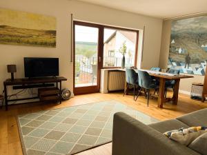 Wiltingen的住宿－Haus Rosenberg，客厅配有桌子和电视