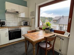 cocina con mesa de madera y ventana en Haus Rosenberg, en Wiltingen