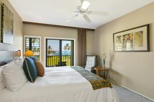a bedroom with a white bed and a balcony at Prime Oceanfront Condo near Shipwreck Beach - Alekona Kauai in Koloa +16 photos