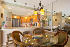 a dining room with a glass table and chairs at Prime Oceanfront Condo near Shipwreck Beach - Alekona Kauai in Koloa