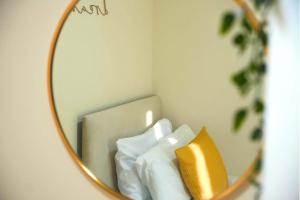 a mirror in a room with a yellow and white pillow at Luxury Home near NEC, BHX with Parking and Netflix in Solihull