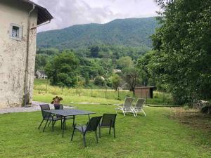 a table and chairs in a yard with a view at Au bord du gave in Laruns