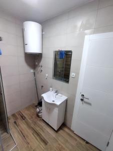ズラティボールにあるApartman Savićの洗面台と鏡のある白いバスルーム +3枚の写真