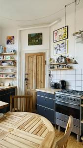 una cucina con piano cottura e tavolo in una stanza di ApartmentInCopenhagen Apartment 1586 a Copenaghen