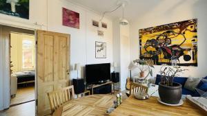 a living room with a dining room table and a painting at ApartmentInCopenhagen Apartment 1586 in Copenhagen