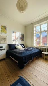 una camera da letto con un grande letto e un piumone blu di ApartmentInCopenhagen Apartment 1586 a Copenaghen