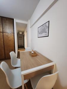 a dining room with a wooden table and white chairs at LUAMAR 2-SAINT MICHELE in Mar del Plata